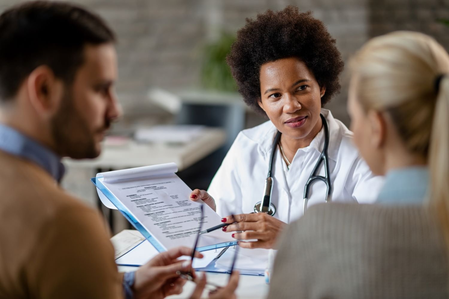 african-american-female-doctor-showing-couple-test-results-their-medical-exam-clinic